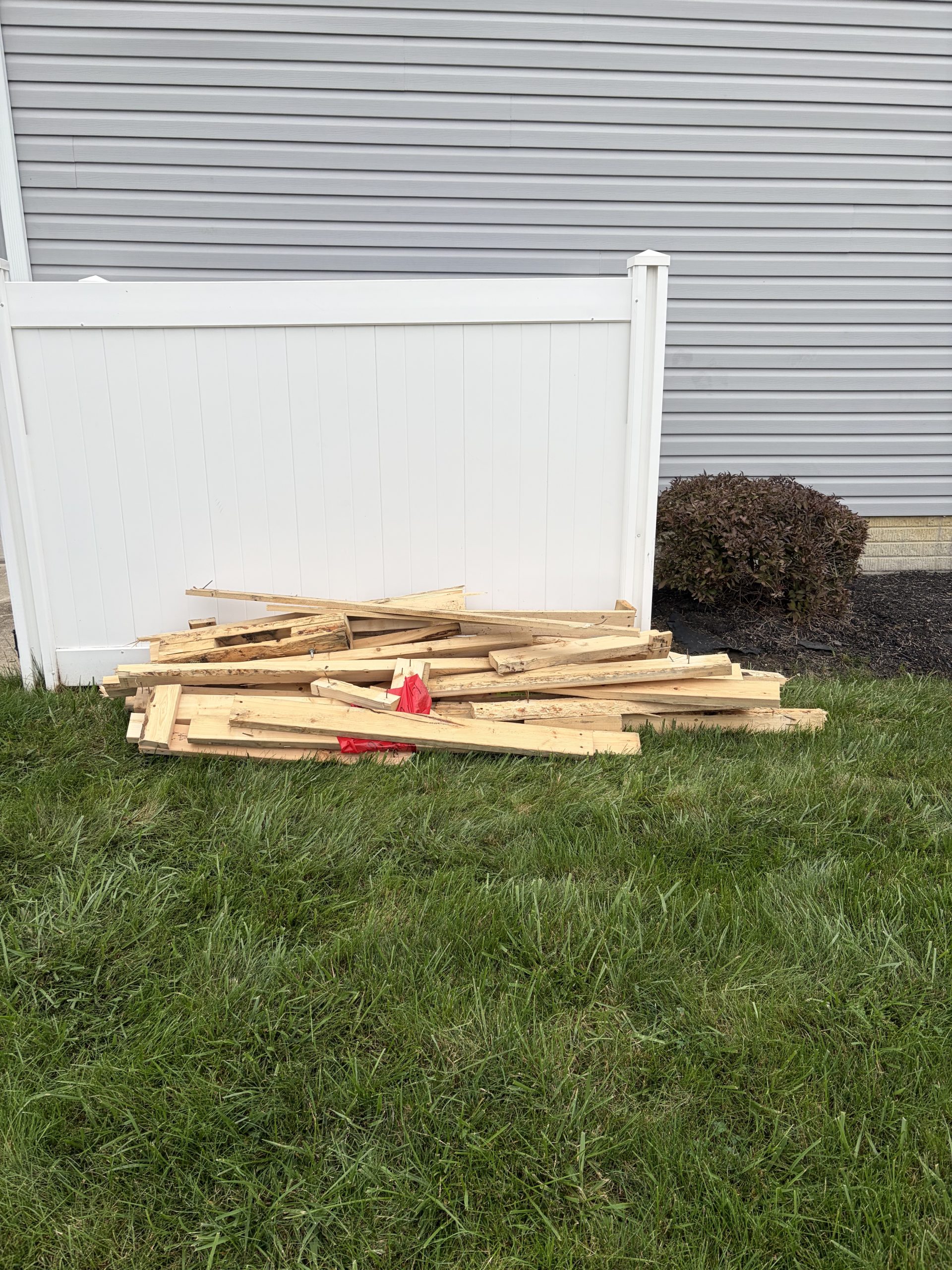 Wood debris piled on lawn before junk removal